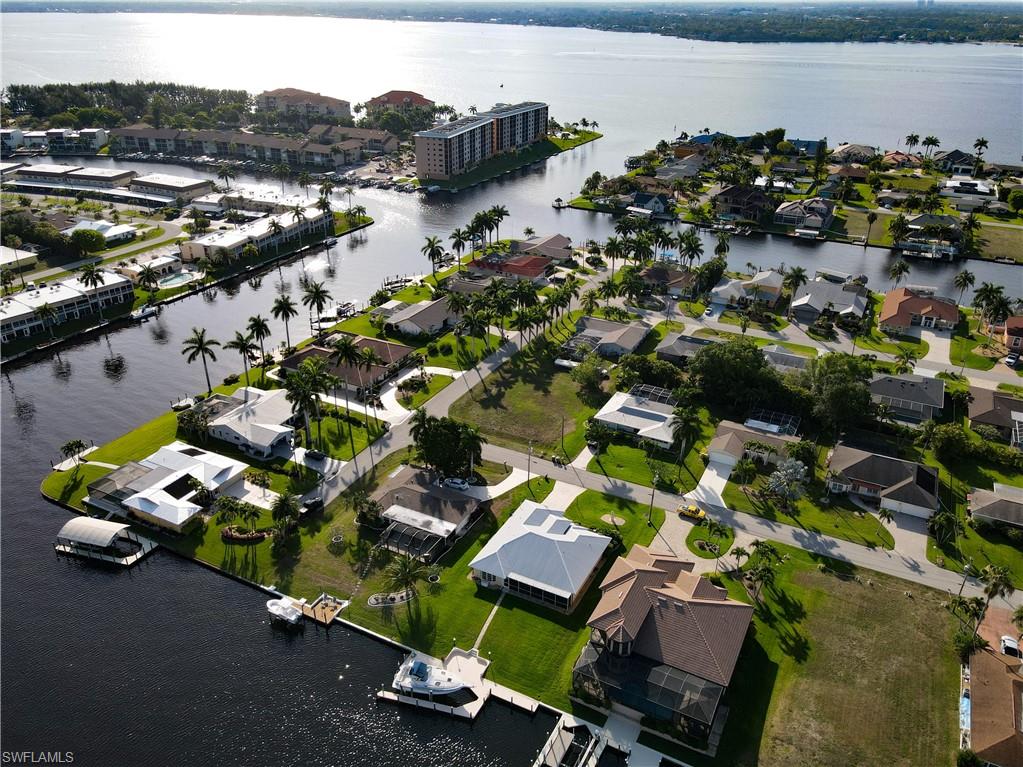 Aerial view of property and surrounding area with a nearby body of water and nearby suburban area