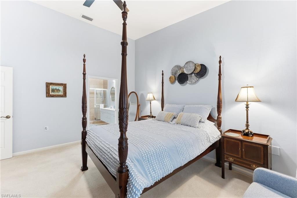 Bedroom with light carpet, a ceiling fan, and ensuite bath