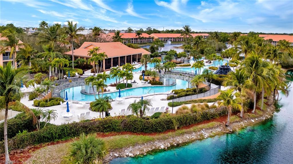 Aerial view of a pool area and a large body of water