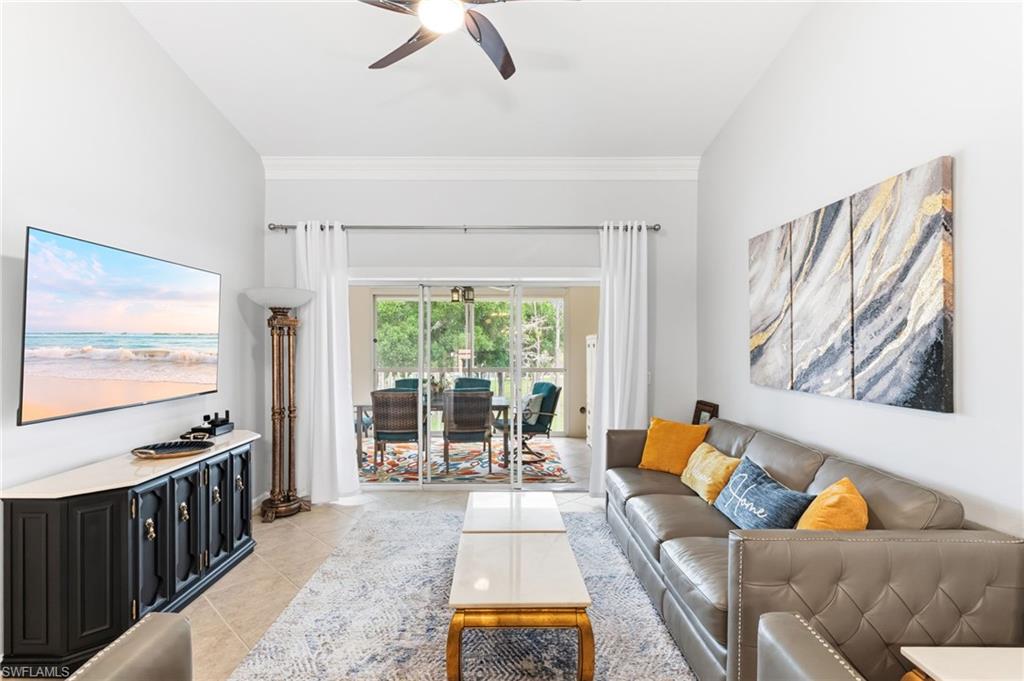Living room with ceiling fan and light tile patterned flooring