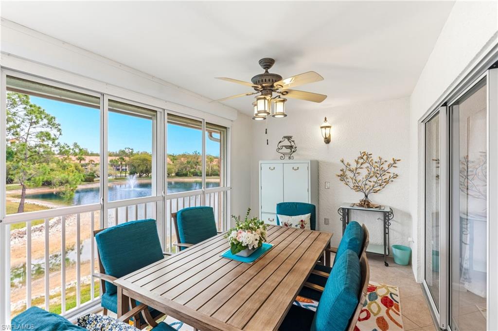 Dining space with ceiling fan, a water view, and light tile patterned floors