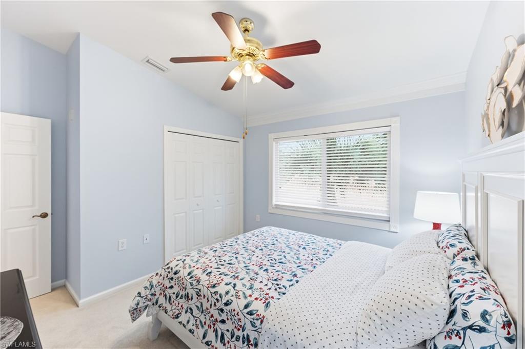 Bedroom with light carpet, vaulted ceiling, a closet, and ceiling fan