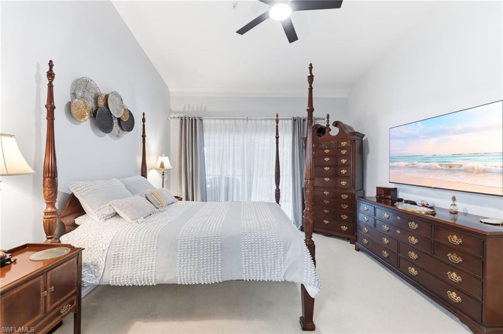 Bedroom with light colored carpet, ceiling fan, and crown molding
