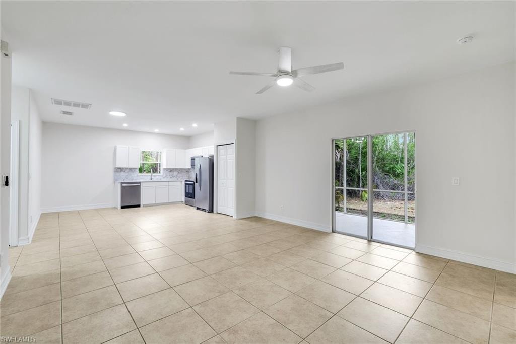 Unfurnished living room with a ceiling fan, light tile patterned floors, and recessed lighting