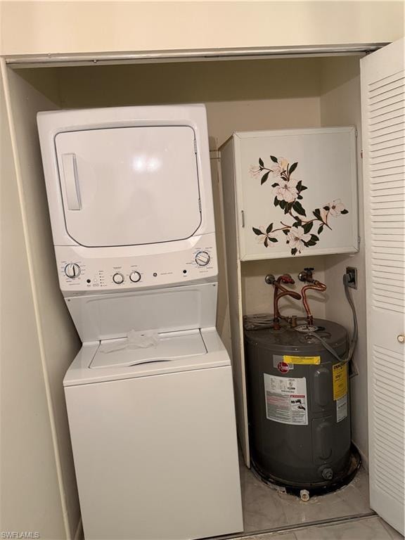 Laundry area with water heater and stacked washing machine and dryer