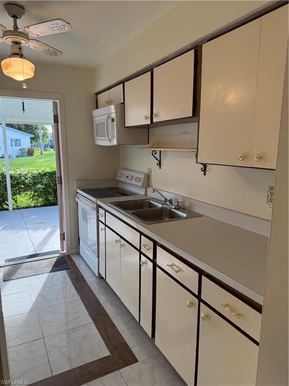 Kitchen featuring white appliances, light countertops, a ceiling fan, and two tone cabinetry
