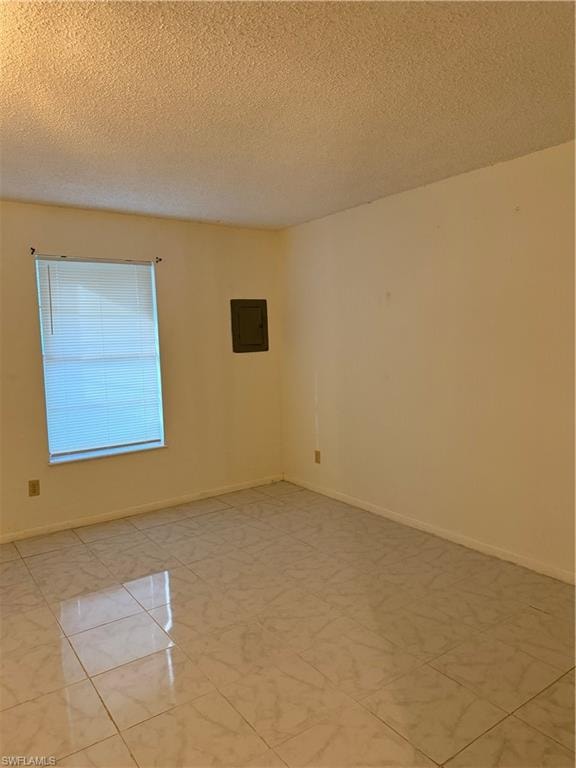 Unfurnished room featuring a textured ceiling and electric panel