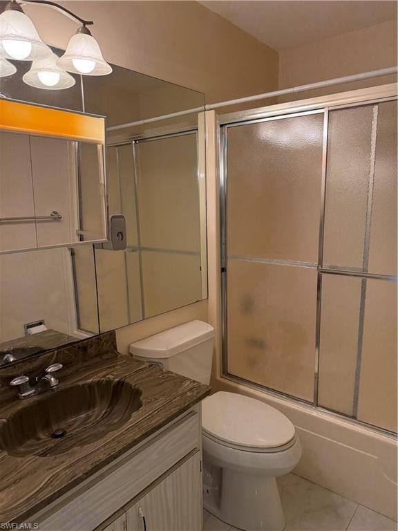 Bathroom with vanity, light tile patterned floors, and shower / bath combination with glass door