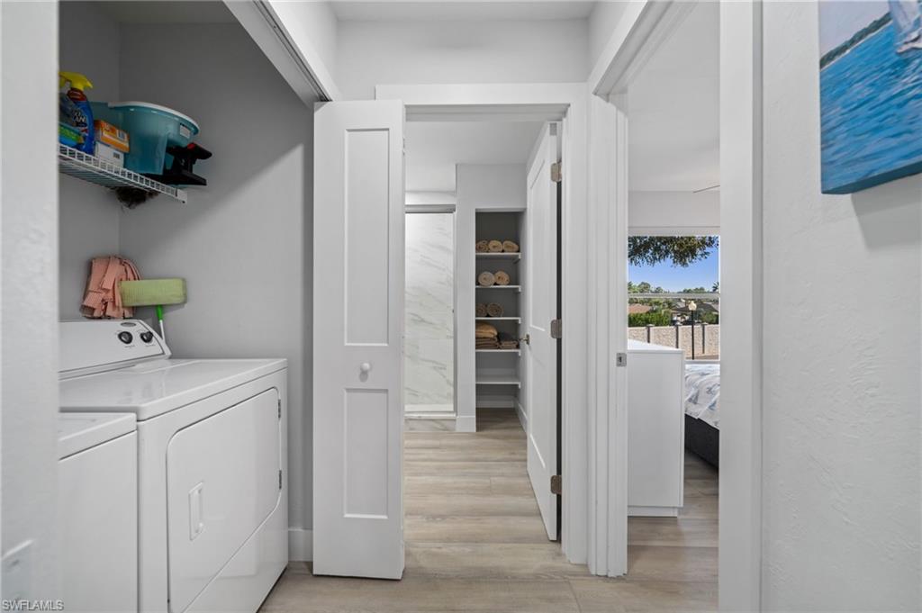 Laundry area featuring light wood finished floors and washing machine and clothes dryer