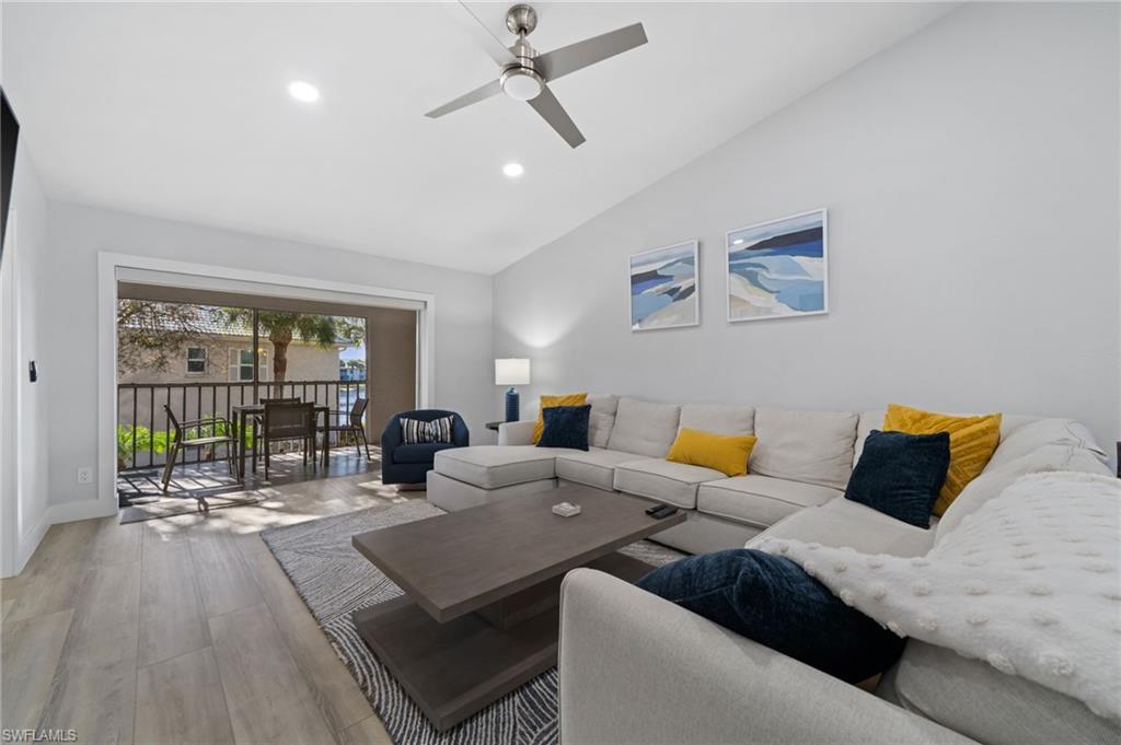 Living area with light wood-type flooring, a ceiling fan, lofted ceiling, and recessed lighting