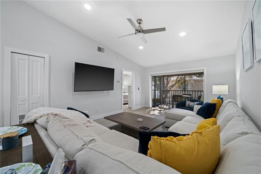 Living area with vaulted ceiling, a ceiling fan, wood finished floors, and recessed lighting