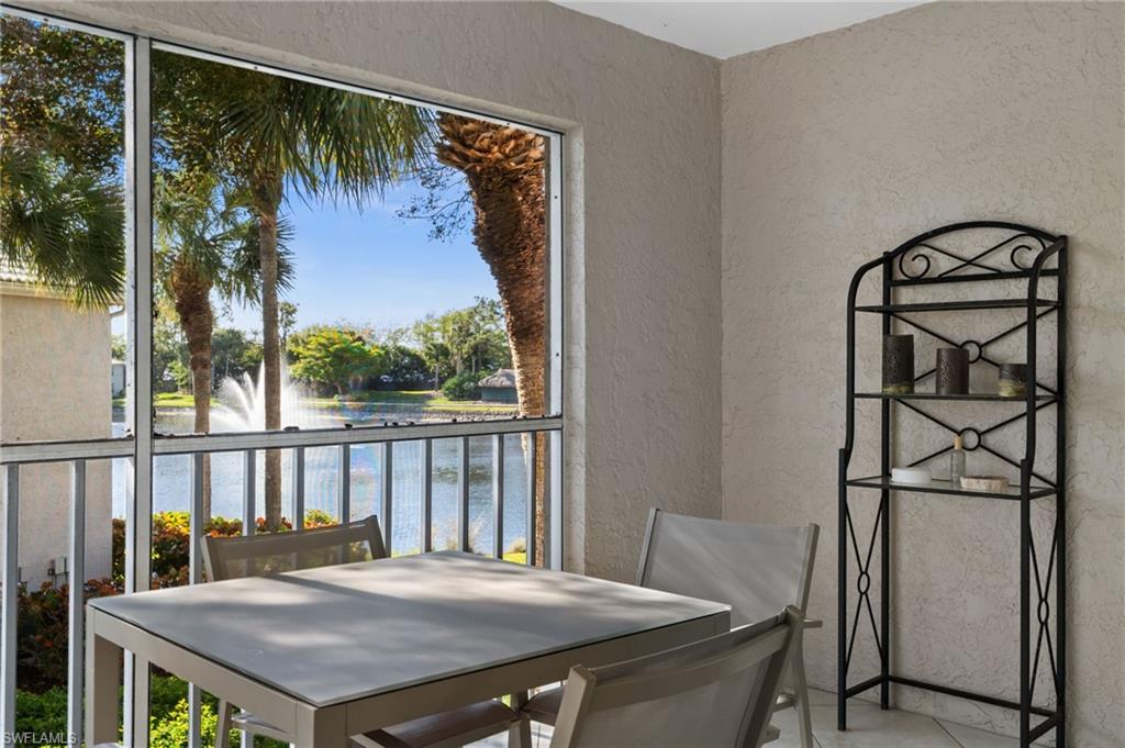Balcony featuring a sunroom, outdoor dining area, and a water view