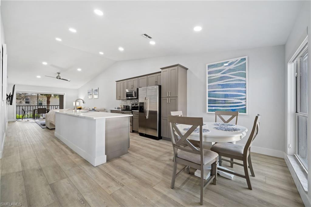 Kitchen featuring gray cabinetry, stainless steel appliances, a center island with sink, recessed lighting, and ceiling fan