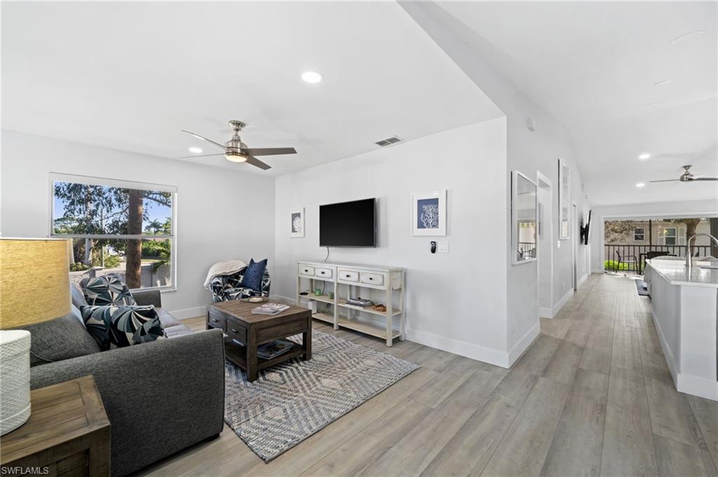 Living room featuring a ceiling fan, light wood-style floors, and recessed lighting