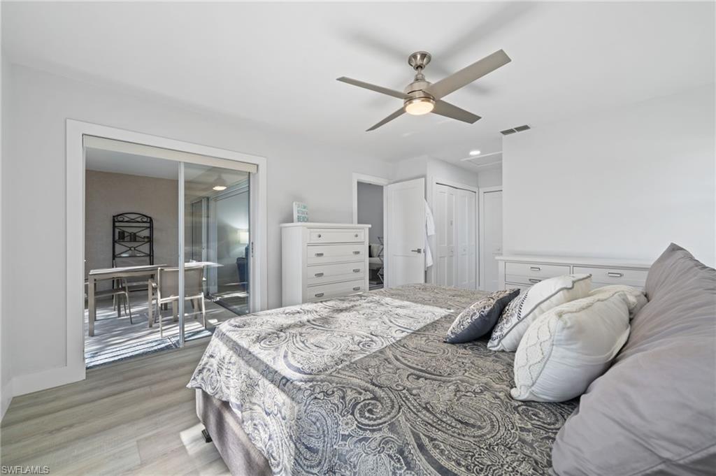 Bedroom with light wood-type flooring, ceiling fan, and a closet