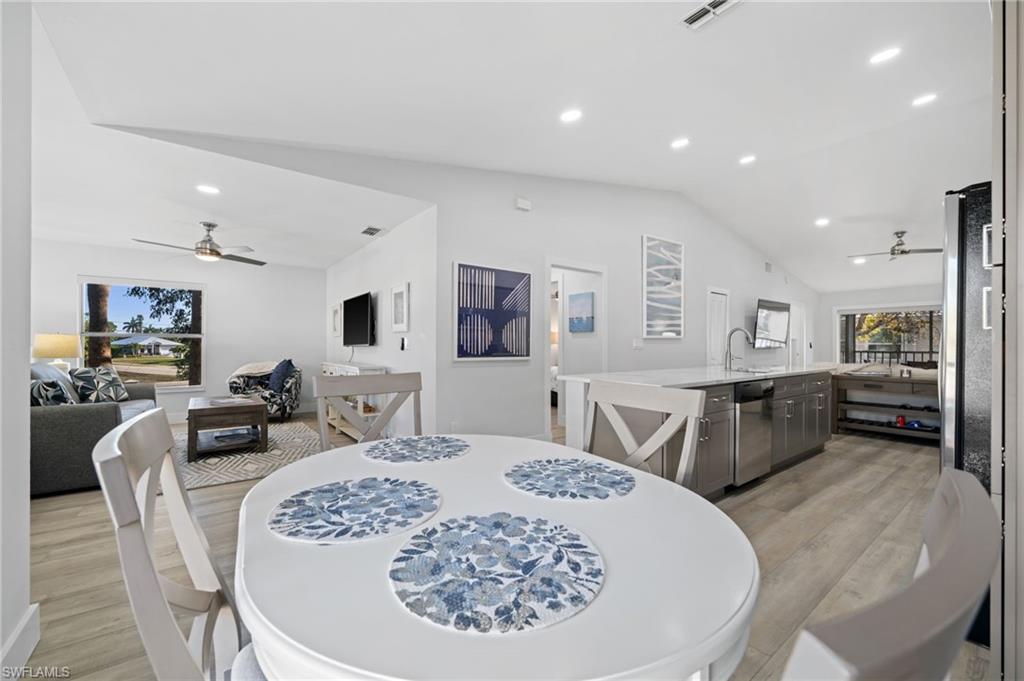 Dining space featuring ceiling fan, light wood-style flooring, vaulted ceiling, and recessed lighting