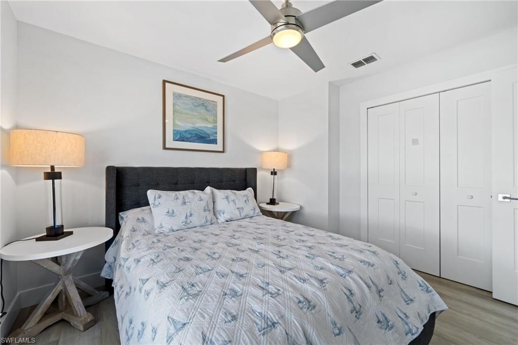 Bedroom with light wood finished floors, ceiling fan, and a closet