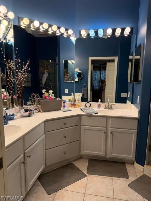 Full bath featuring double vanity, a stall shower, and light tile patterned floors