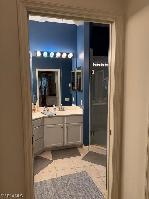 Bathroom featuring vanity, a stall shower, and light tile patterned floors