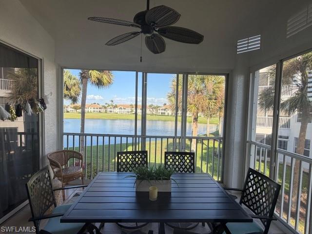 Sunroom with a textured wall, a water view, and healthy amount of natural light