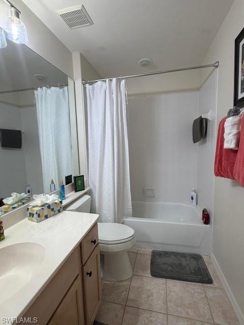 Bathroom with vanity, shower / tub combo with curtain, and light tile patterned floors