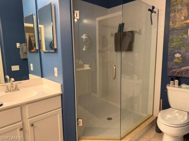 Bathroom featuring vanity, a shower stall, and tile patterned floors