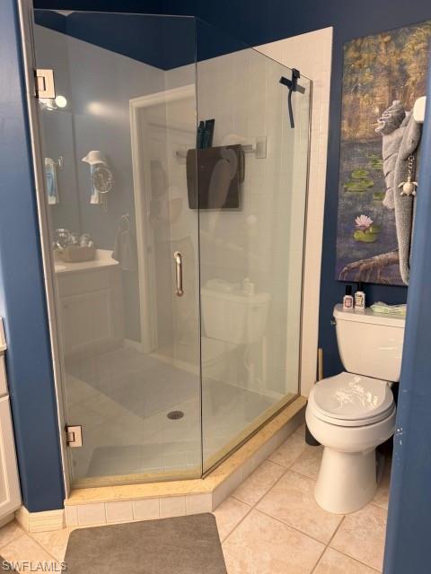 Full bath featuring vanity, a shower stall, and light tile patterned floors
