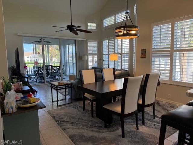 Tiled dining room featuring a ceiling fan and lofted ceiling