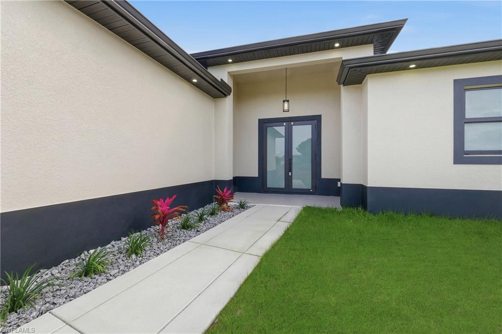 Entrance to property featuring french doors and stucco siding