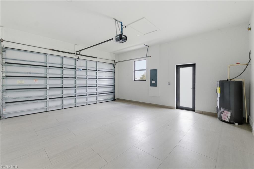 Garage with water heater, electric panel, and a garage door opener