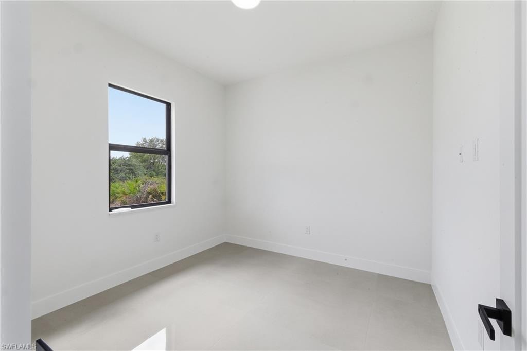 Spare room with baseboards and concrete floors
