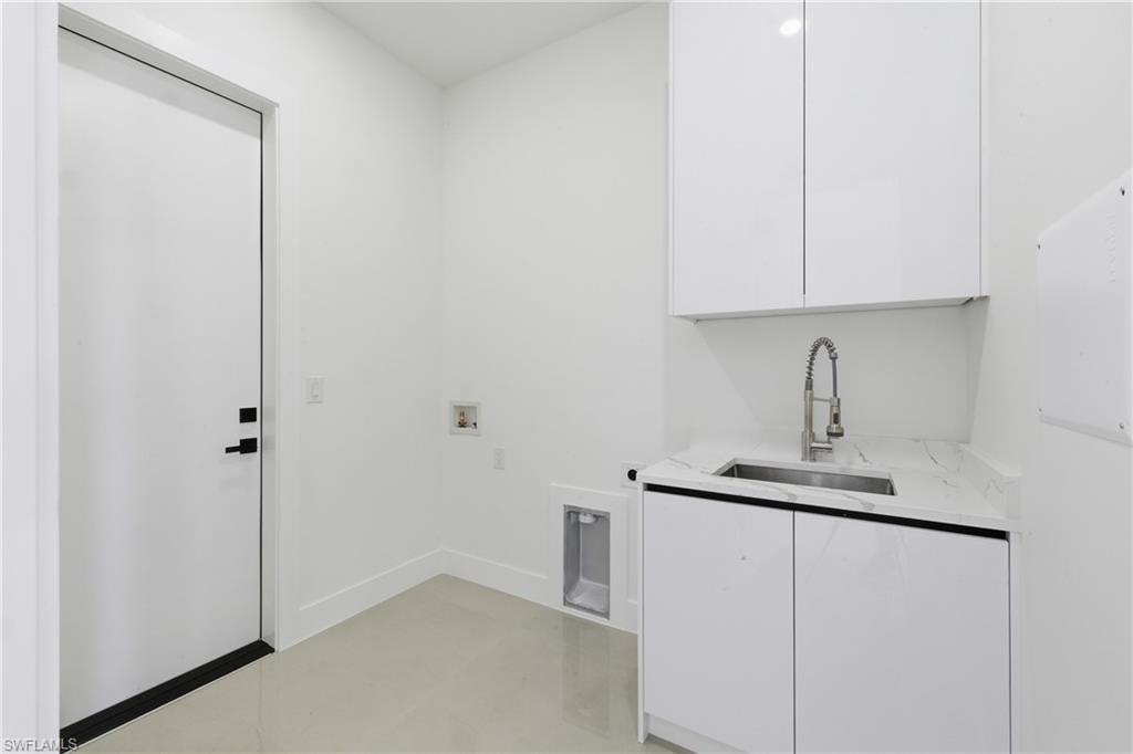 Laundry area with hookup for a washing machine, finished concrete floors, cabinet space, and hookup for an electric dryer