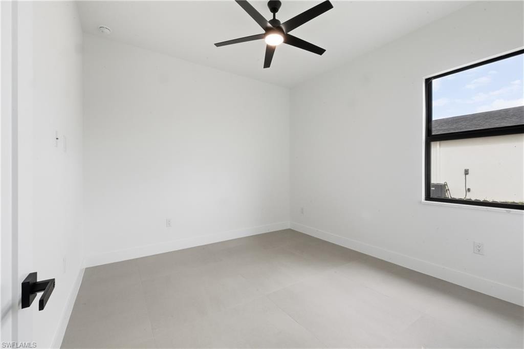 Unfurnished room with concrete flooring and ceiling fan