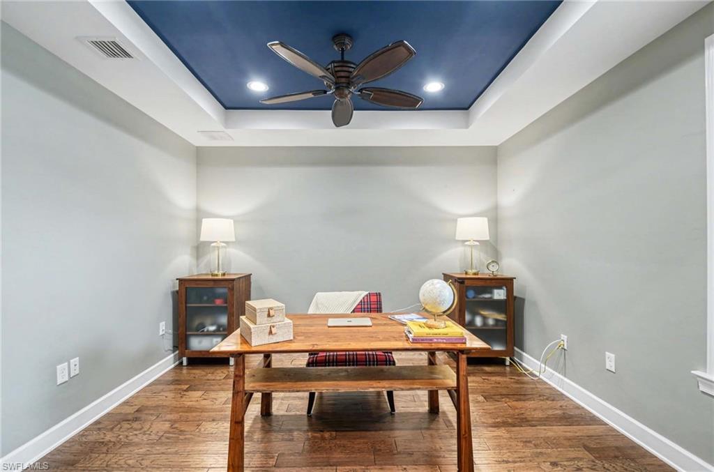 Dining area featuring a raised ceiling, hardwood / wood-style floors, an office area, ceiling fan, and recessed lighting