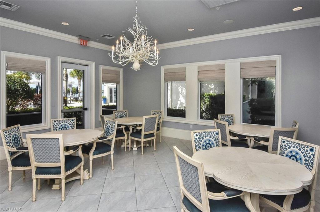 Dining area with light tile patterned flooring, a chandelier, and crown molding