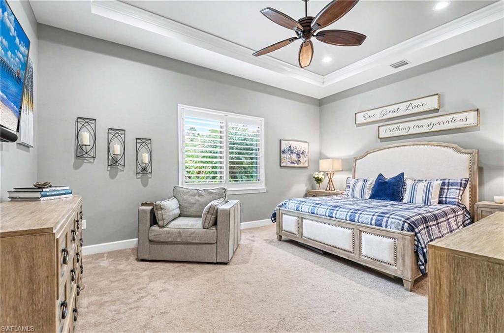 Bedroom with light carpet, ceiling fan, ornamental molding, a tray ceiling, and recessed lighting