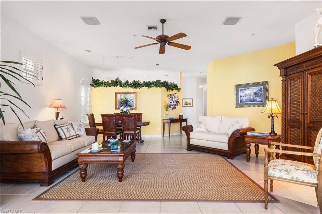 View from patio inside Living Room to Dining Room. Tile floors with area rugs.