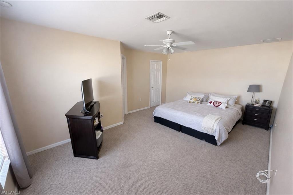 Bedroom featuring light colored carpet and a ceiling fan