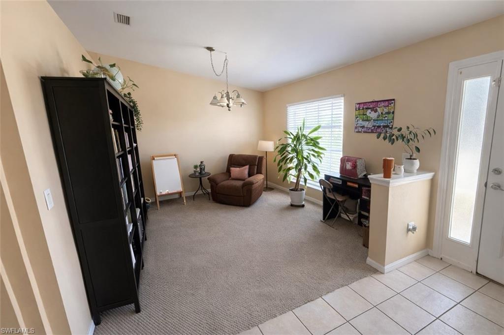 Office space with light carpet, light tile patterned flooring, and a chandelier