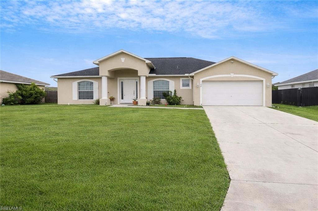 Ranch-style home featuring stucco siding, an attached garage, and concrete driveway