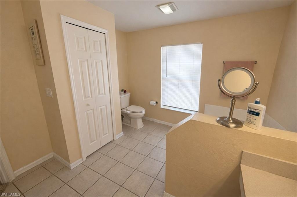 Bathroom featuring a closet, light tile patterned flooring, and vanity