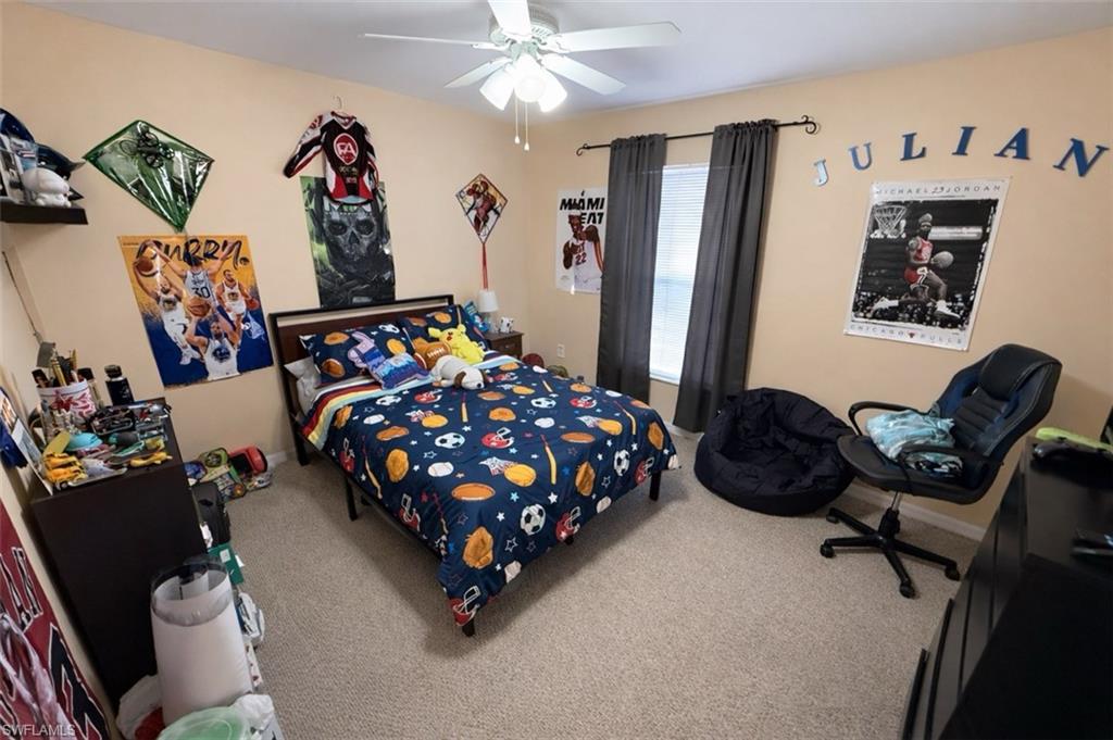 Carpeted bedroom featuring ceiling fan