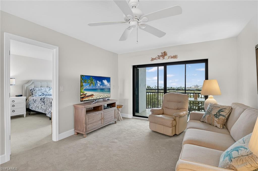 Living room with light colored carpet and a ceiling fan