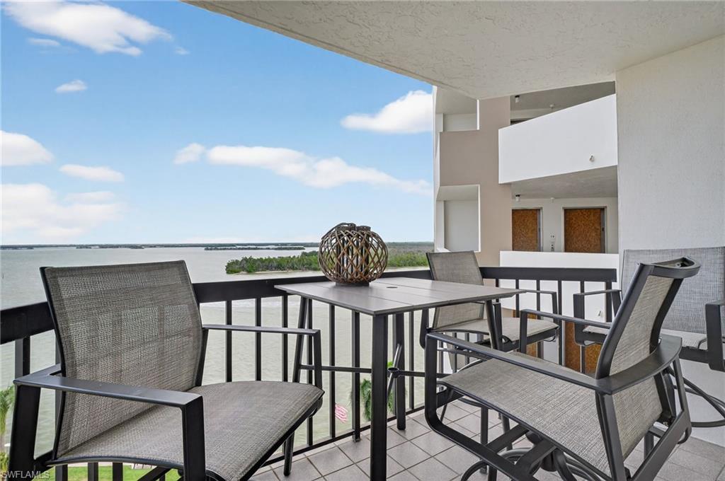Balcony featuring a water view and outdoor dining area