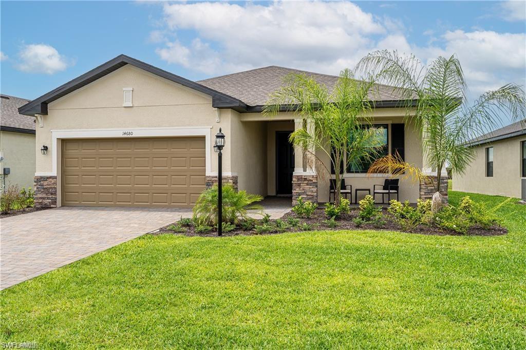 View of front of house with stone siding, stucco siding, an attached garage, and driveway