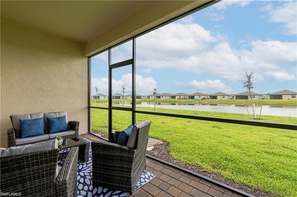 Sunroom featuring a residential view, a water view, and outdoor furniture