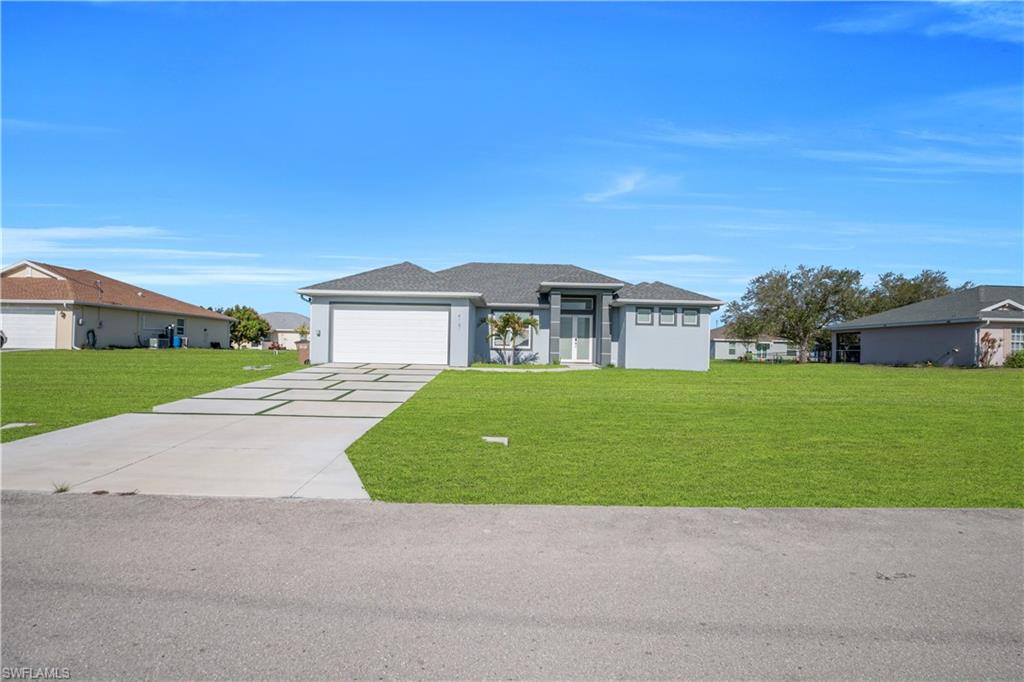 Prairie-style house with a front lawn, concrete driveway, and an attached garage