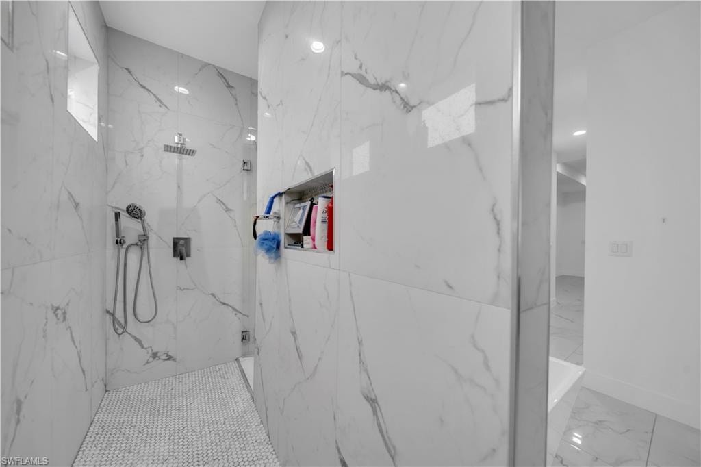 Full bathroom with a marble finish shower