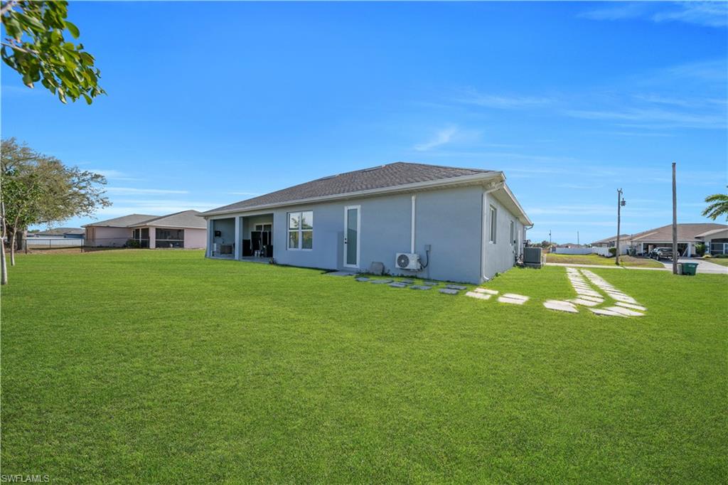 Rear view of property with a yard and stucco siding