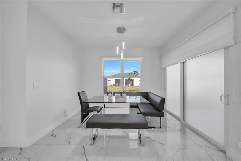 Dining space featuring light marble finish floors